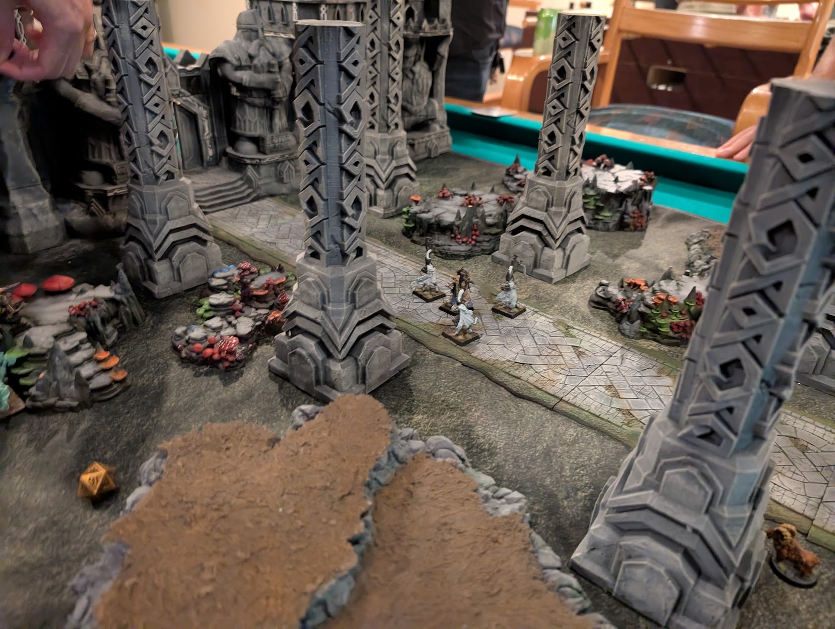 Miniatures face off among towering pillars, rocky outcrops, and the gates of the dwarven fortress.